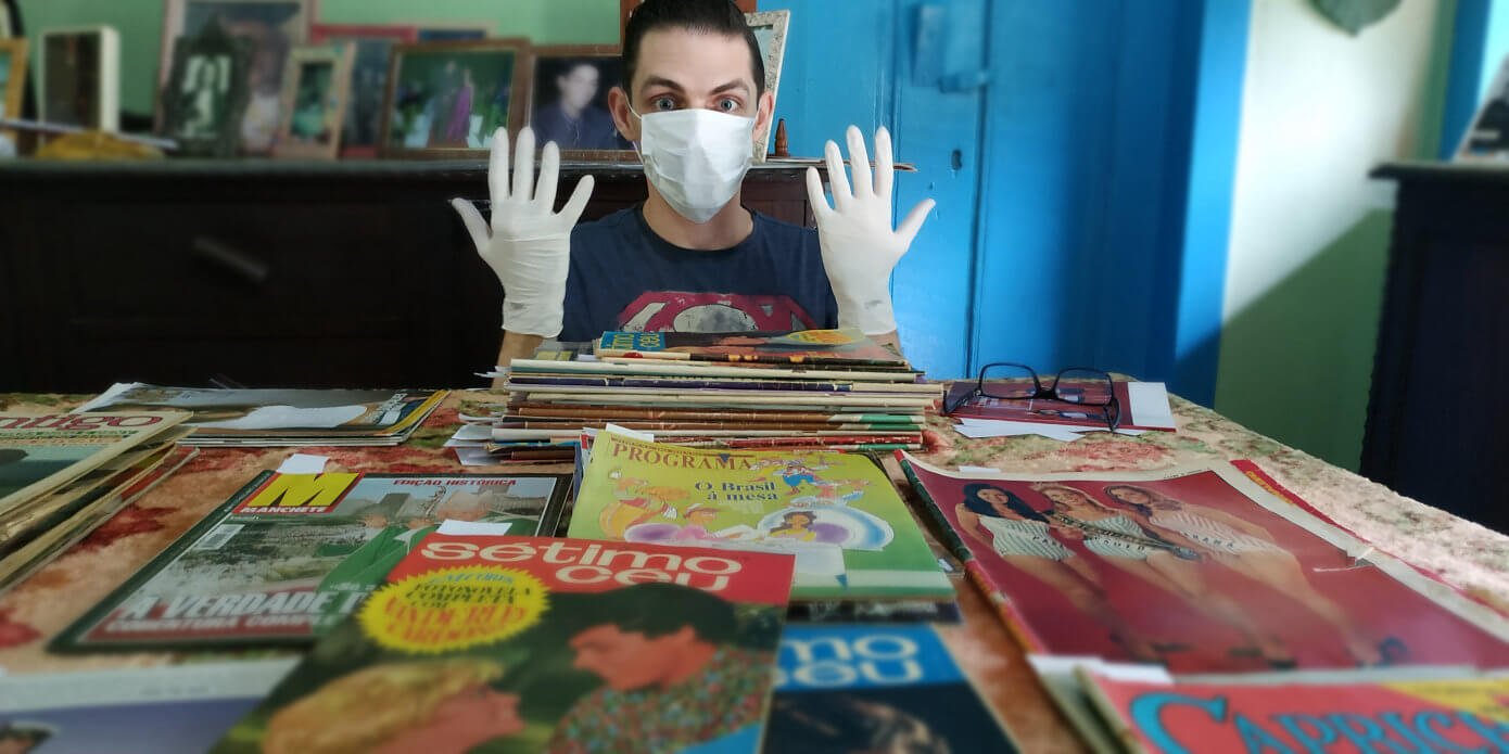 Luan Volpato de máscara e luvas pronto para manusear o acervo mais antigo de revistas de Gercy Volpato.
